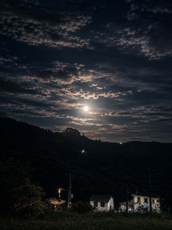 imagen exterior de la casa por la noche con la luna llena